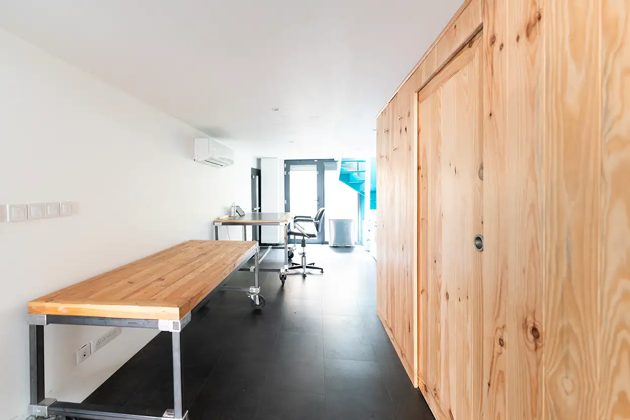 Couloir accès plateau Greystone Studio, table de travail bois et climatisation réversible Villeurbanne