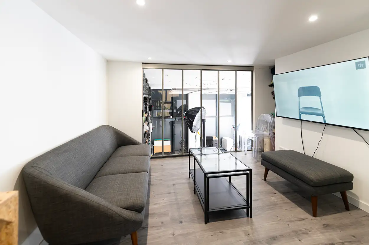 Espace détente loge Greystone Studio, canapé, table basse et vue vitrée sur plateau de prise de vue