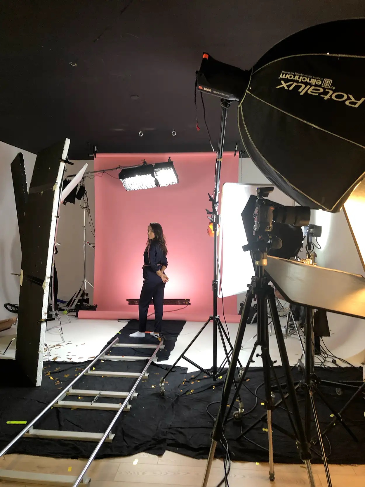 Modèle en tenue sombre sur fond rose motorisé, Elinchrom Rotalux et panneau LED au premier plan, plateau Greystone Studio Villeurbanne Lyon