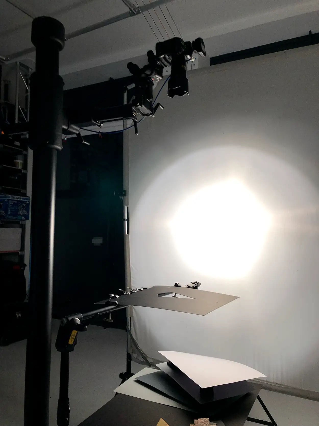Caméra montée en hauteur sur bras articulé au-dessus d'un plateau packshot éclairé par grand octobox, Greystone Studio Villeurbanne Lyon