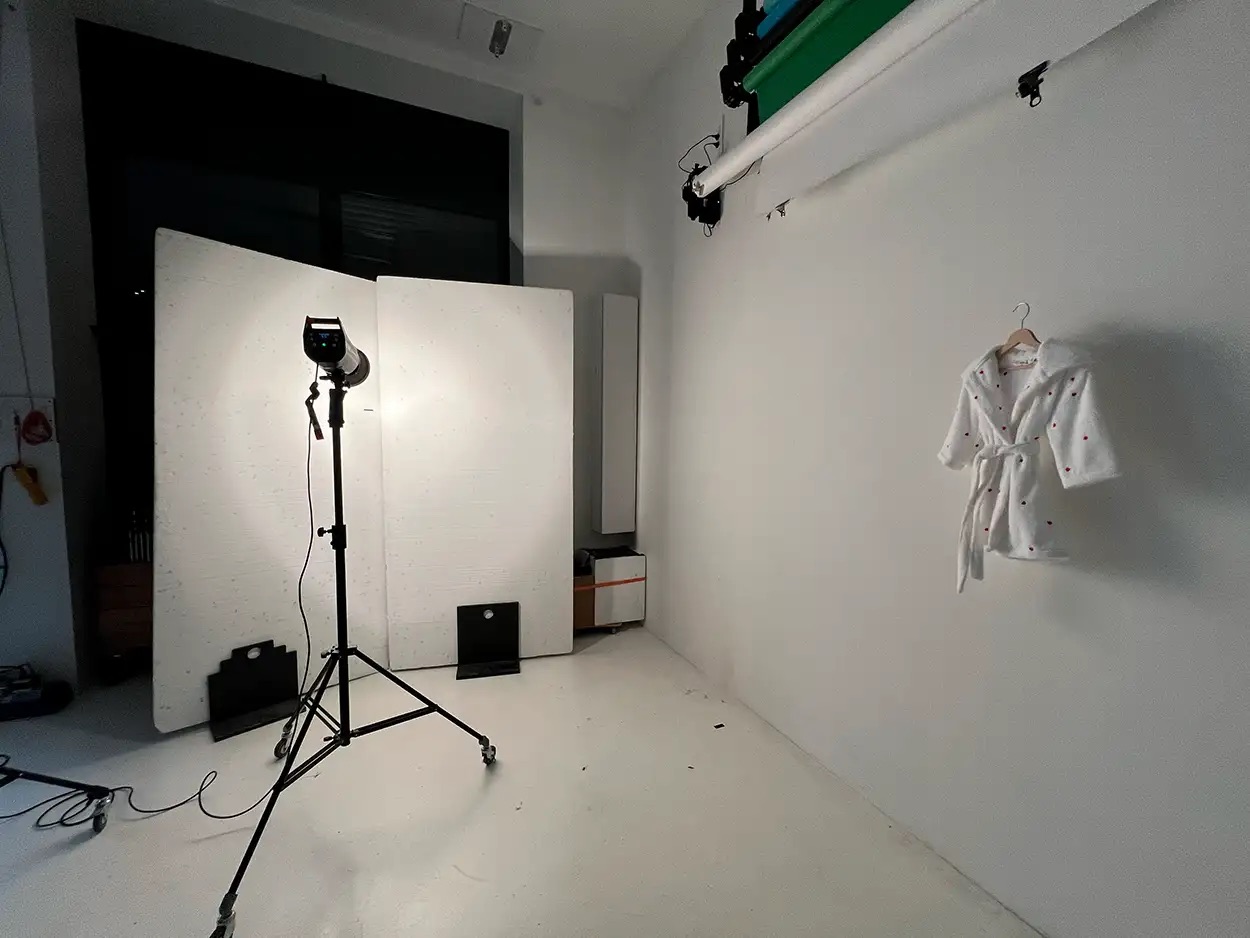 Setup shooting packshot textile — peignoir enfant suspendu sur fond blanc motorisé avec flash studio, plateau Greystone Studio Villeurbanne Lyon