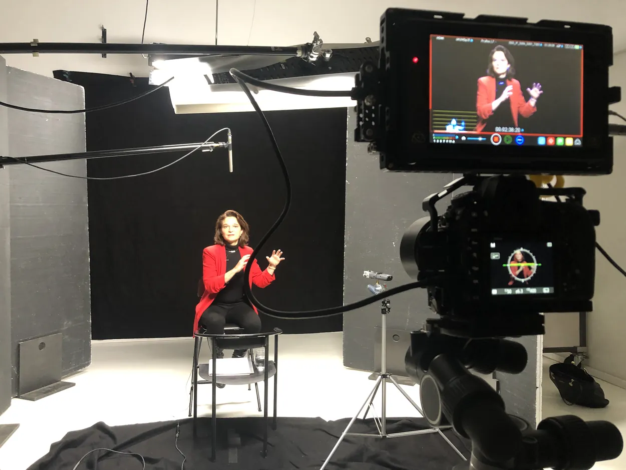 Tournage d'une interview en studio : intervenante assise sur fond noir, caméra sur pied et retour vidéo, Greystone Studio, Villeurbanne Lyon