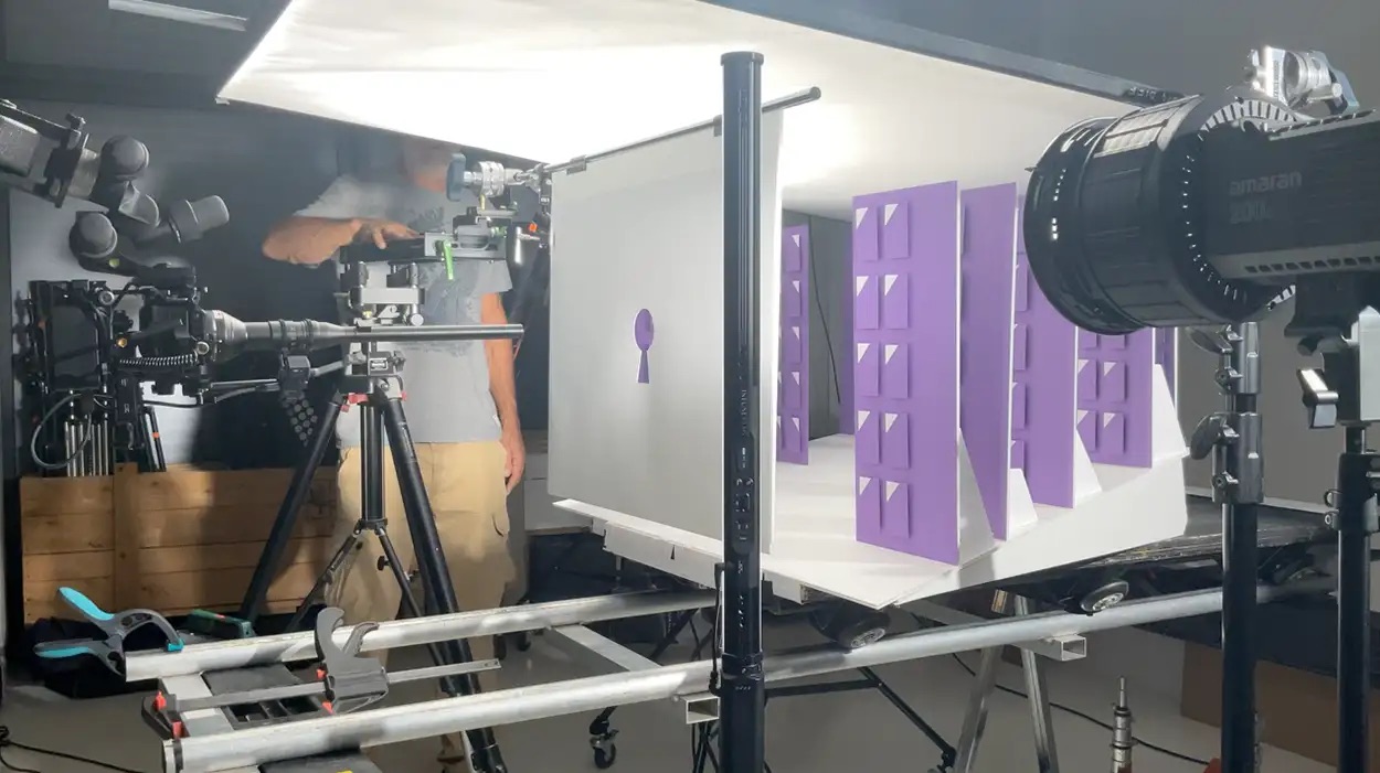 Setup packshot produit sur plateau violet avec décor cartonné, caméra cinéma sur rails et projecteur Amaran, Greystone Studio Lyon