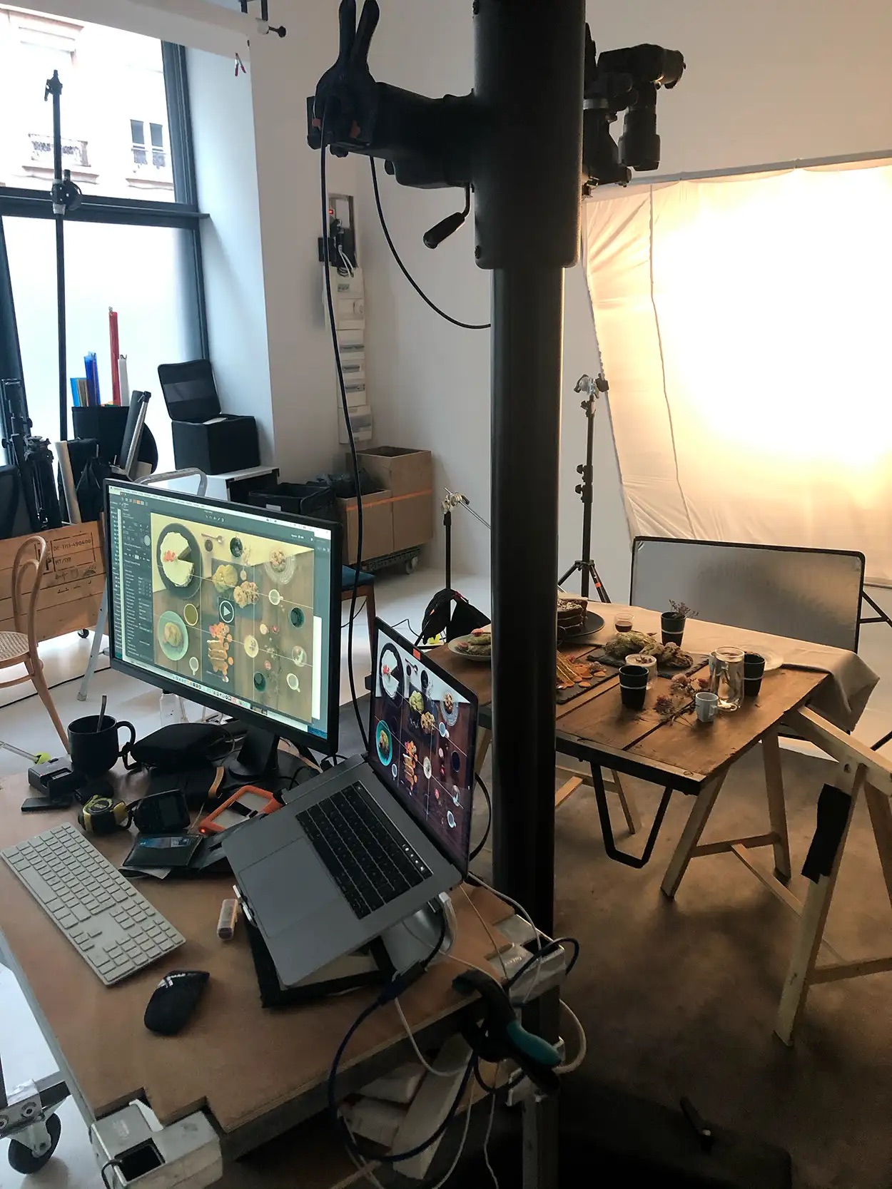 Station tethering avec grand écran et MacBook affichant des visuels food, plateau shooting en arrière-plan, Greystone Studio Lyon