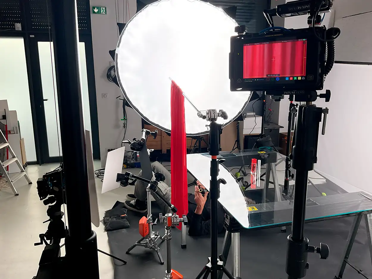 Moniteur Atomos Shogun affichant un produit rouge, réflecteur circulaire et table en verre, plateau packshot Greystone Studio Villeurbanne