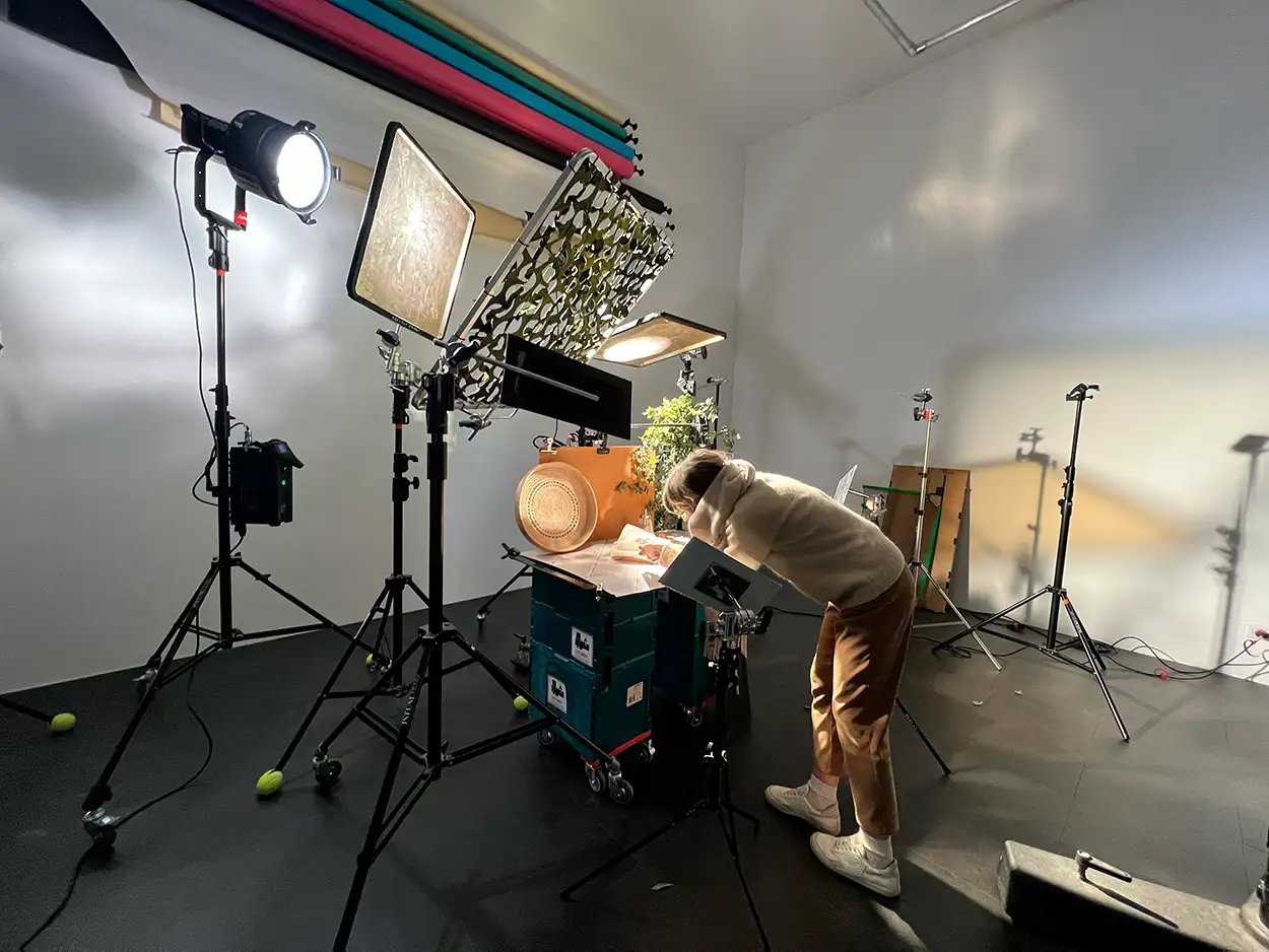 Photographe préparant un plateau packshot alimentaire avec produit orange, LED et softbox, fonds papier colorés Greystone Studio Lyon