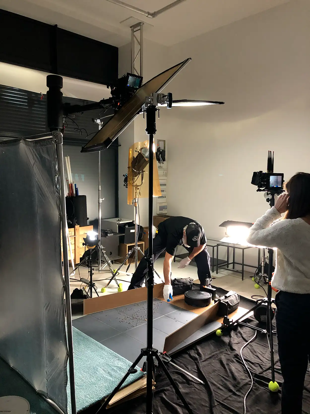 Équipe préparant un plateau packshot high-tech avec flash Fresnel et caméra sur fond sombre, Greystone Studio Lyon
